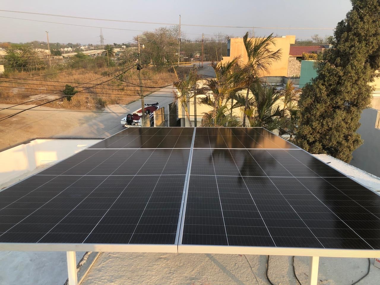 Imagen de unos paneles solares en el tejado de una casa que aprovechan la luz solar para producir energía renovable y reducir la factura de la luz