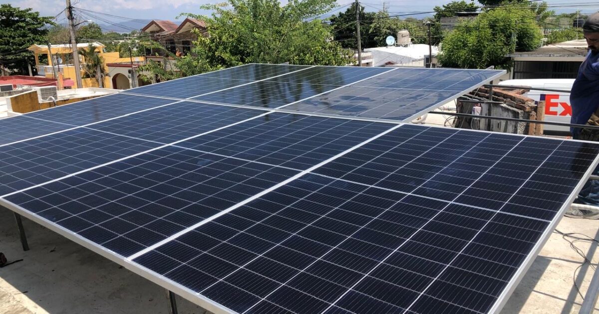 Paneles solares en un techo en medio de una ciudad. Energía limpia y sostenible para el desarrollo urbano.