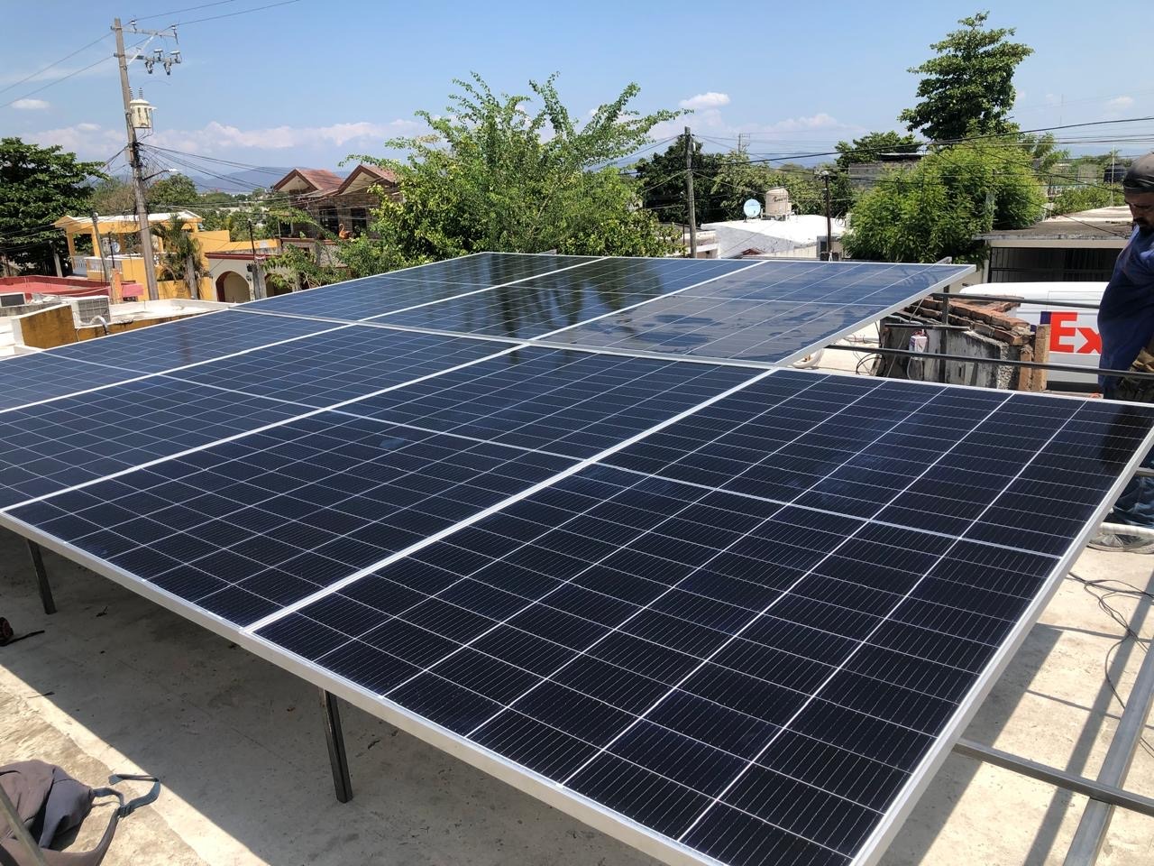 Paneles solares en un techo en medio de una ciudad. Energía limpia y sostenible para el desarrollo urbano.